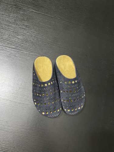 THE ROW这双穆勒拖鞋，浅米色麂皮材质，质感满满。独特的镂空圆孔设计，打破单调，为整体造型增添灵动感 。一脚蹬的便捷款式，轻松适配各种夏日出街look，时髦