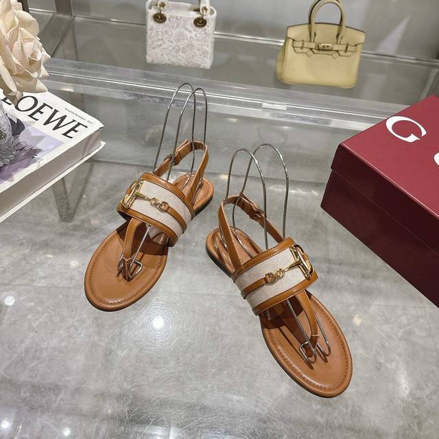 8023-2 棕布 35-43 这款女士夹趾凉鞋搭配饰经典马衔扣细节金色调配件，彰显品牌传承。采用精致绒面材质打造，设计优雅而不失随性，是温暖季节的理想单品。