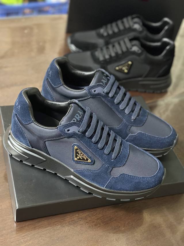 2Ee436 这款运动鞋以Re-Nylon与绒面牛皮革鞋面呈现混搭风动感廓形，搭配舒适的鞋底。重新诠释经典款型Prax，饰以Pra＊＊徽标。 带徽标鞋带 鞋面饰