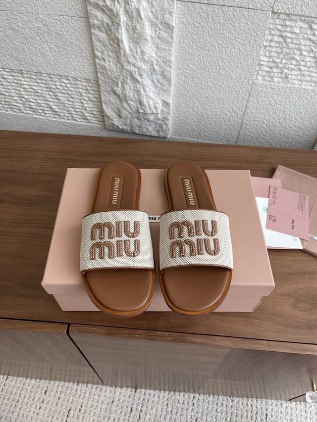 顶级版本: Miu Miu 缪缪 25Ss 夏装新品 帆布 平底 拖鞋 这款凉鞋采用休闲帆布材质和精致皮革徽标细节，鞋面饰有皮革字母徽标，平底一字潮，拖以丰富对