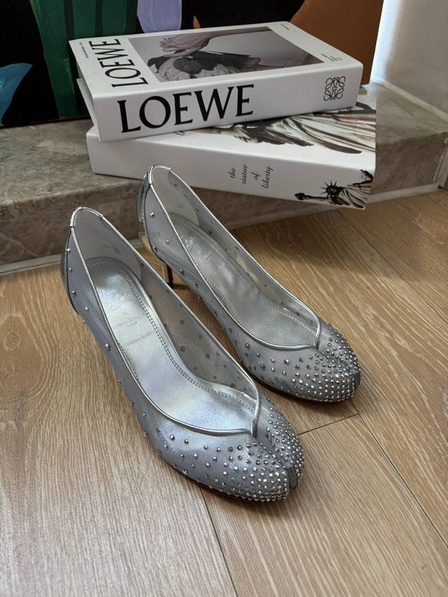 Maison Margiela By Christian Louboutin借用了经典Tibi分趾鞋型，在此基础上融入红底鞋品牌的女性化轮廓，以及标志性色彩、材