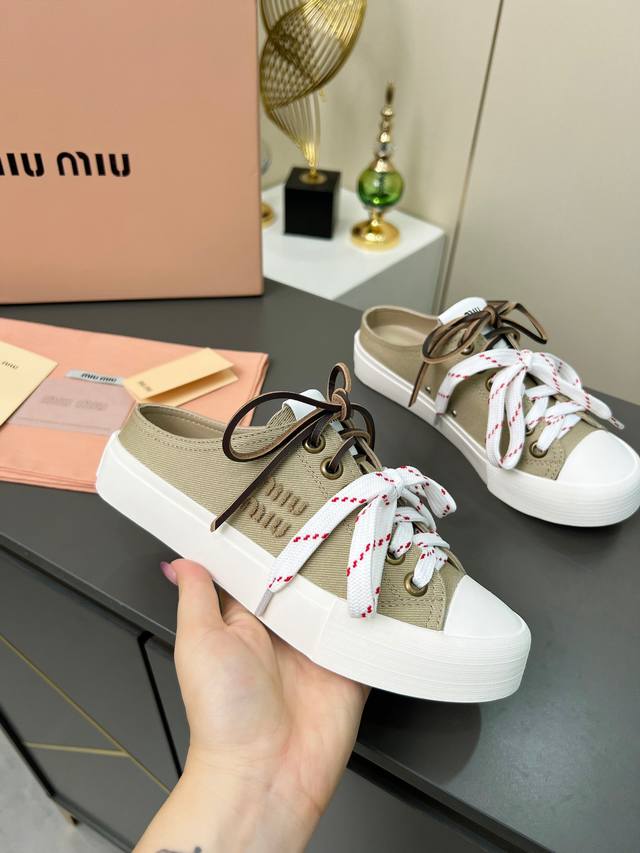 缪缪 Miumiu2025春夏时尚新品，新增薄底轻便帆布小白鞋双色鞋带，体现了Miu Miu 的大胆特色，尽展女士魅力，简约线条 ，别致徽标饰于鞋舌点缀，现代风