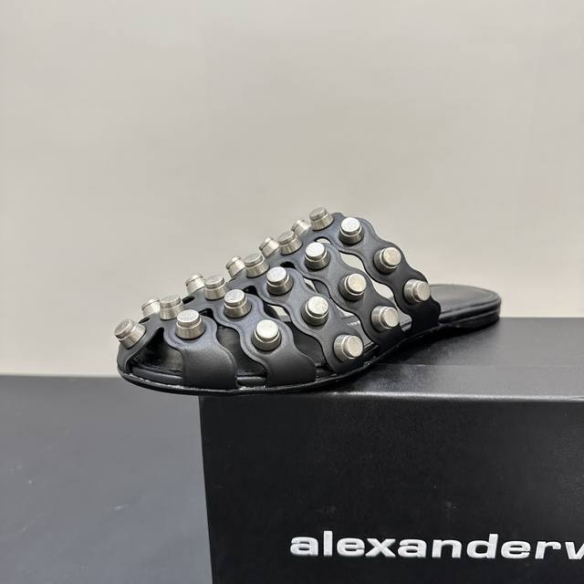 Alexander Wang亚力山大王 2025平底铆钉拖鞋独特铆钉元素，个性前卫，黑白双色经典百搭。鞋面镂空设计，兼具潮流感与透气性。无论是搭配休闲装出街，还