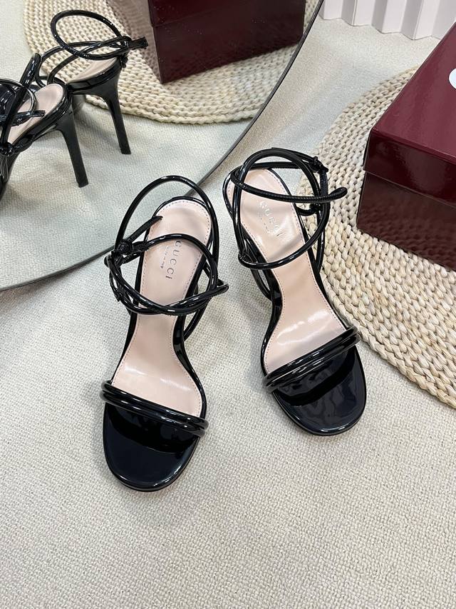 Gucci 24Ss新款 G家圆条款高跟鞋 交叉造型配件为一系列女士鞋款注入摩登新韵。这款后系带高跟凉鞋以闪亮漆皮材质匠心打造，鞋面缀饰简约的圆条 后带同色五金