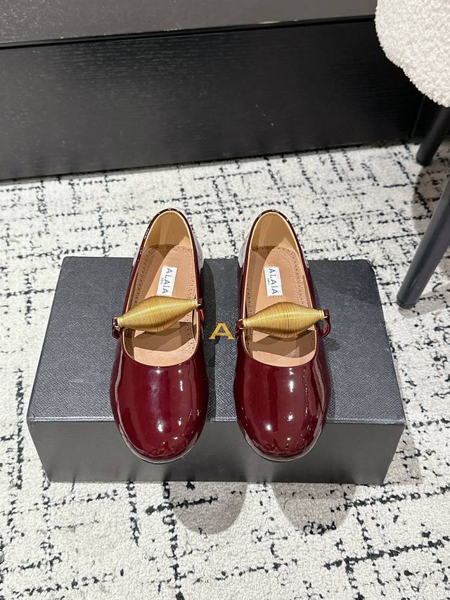 Alaia 25 Aw新品阿萊雅个性弹簧五金扣玛丽珍单鞋 该款平底芭蕾舞鞋，搭配金色润饰螺旋珠宝饰带;橡胶鞋底带来舒适穿着体验;鞋面为漆面小牛皮制成，穿着场合不