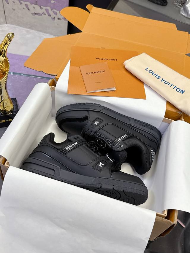 工厂P价P： 本款 Lv Trainer 运动鞋致意 Pharrell Williams 与 Nigo 在 2025 秋冬男装秀场的联袂合作，以工致饰钉为光滑牛