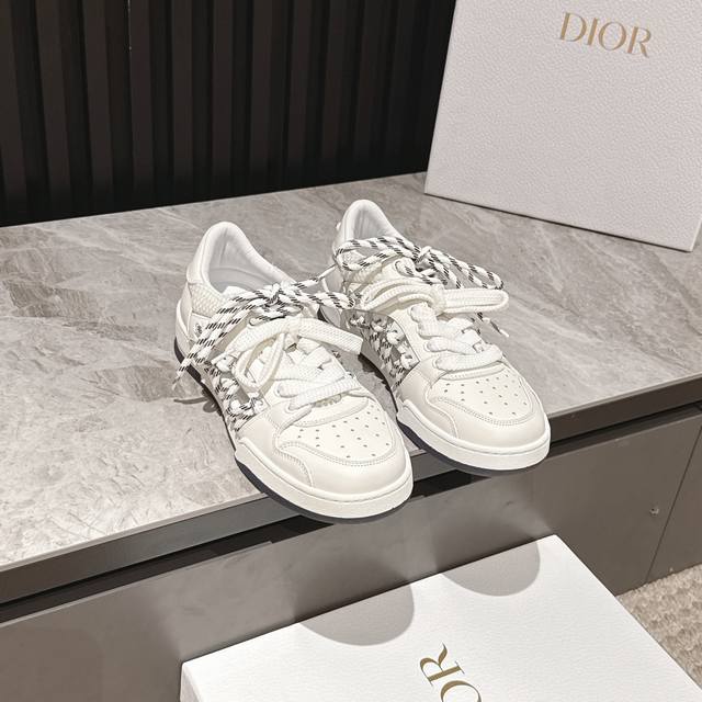 迪奥新款情侣码镂空双色鞋带低帮运动鞋这款 Dior First 高帮运动鞋是2025春夏成衣系列新品，以 Dior 的高订视角重新诠释运动服饰经典标识。白色牛皮