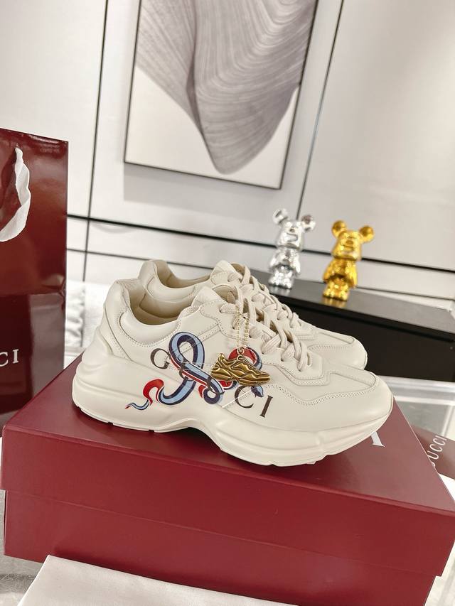 Gucci蛇年限定新品 Rhyton系列情侣款老爹鞋 运动鞋 Rhyton系列推出全新象牙白色皮革款式，巧妙结合该系列标志性的超大造型鞋底和厚实结构。这款经典鞋