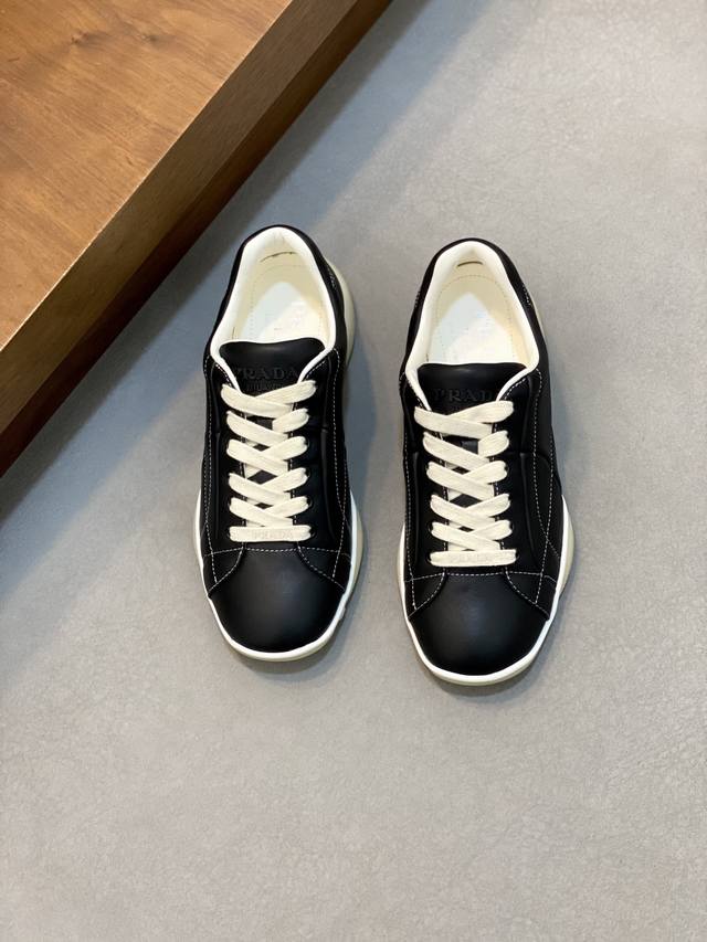 Prada 普拉达 新款男士拼接休闲运动鞋 这款运动鞋以精湛的缝线工艺勾勒出别具一格的几何纹理，当代风格线条与细节重新演绎经典的运动风格。采用超柔超韧羊皮鞋面，