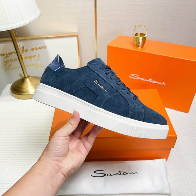 Santoni 圣东尼 这是一款男士低帮运动鞋，由意大利制造。 材质与构造：采用翻毛皮制作，未加内衬且解 构设计，呈现简约风格。 颜色与细节：鞋身为兰色，鞋舌和