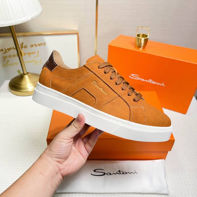 Santoni 圣东尼 这是一款男士低帮运动鞋，由意大利制造。 材质与构造：采用翻毛皮制作，未加内衬且解 构设计，呈现简约风格。 颜色与细节：鞋身为土黄色，鞋舌