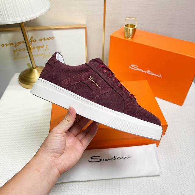 Santoni 圣东尼 这是一款男士低帮运动鞋，由意大利制造。 材质与构造：采用翻毛皮制作，白色羊里，呈现简约风格。 颜色与细节：鞋身为酒红色，鞋舌和鞋跟处饰有