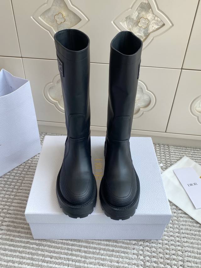 代购级Dior 迪奥D-Scots新品中筒靴 布洛克长靴 这款 D-Scots 靴子是二零二五早春成衣系列新品，彰显高订魅力。黑色橡胶效果牛皮革筒形设计，侧面饰