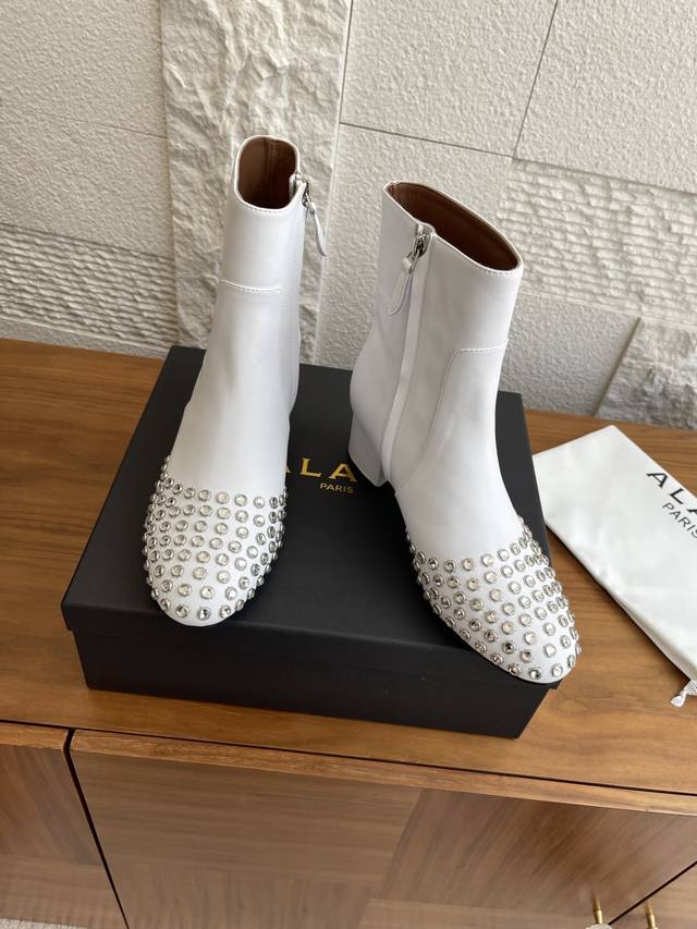 顶级版本： Alaia 阿莱亚 25Ss 秋冬新款 圆头 水钻铆钉 侧拉链 粗跟 短靴 Alaia这款时尚短靴太绝啦！采用麂皮质感高级，鞋头水晶钻铆钉圈设计超吸