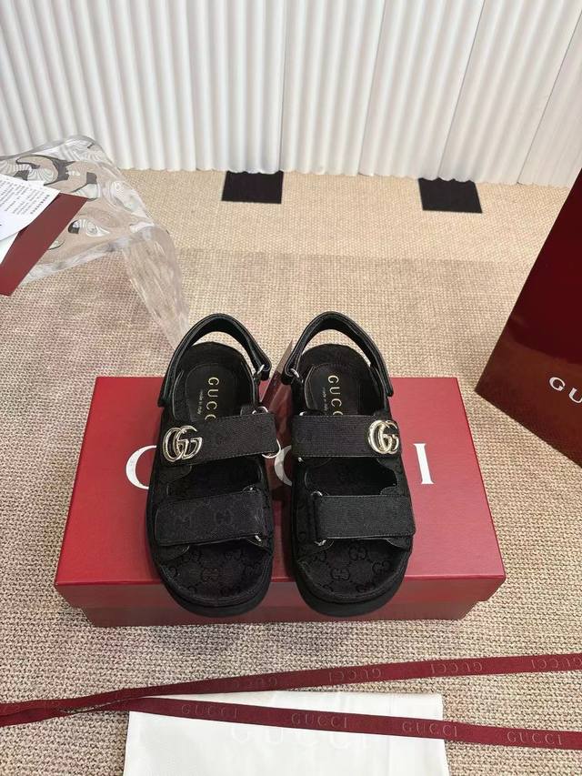Gucci 古弛凉鞋 25Ss 春夏新款，这款平底凉鞋采用魔术粘带设计，现代感十足且充满运动气息，带来舒适感受。 这款配饰以黑色和灰色牛仔布匠心打造，鞋面绑带缀