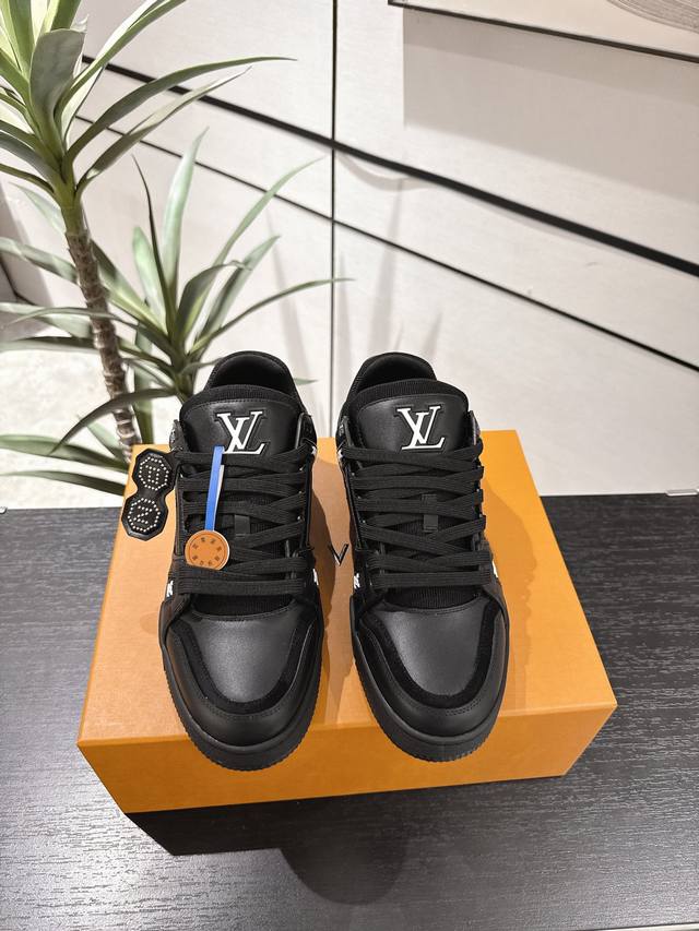 工厂P价P： 本款 Lv Trainer 运动鞋致意 Pharrell Williams 与 Nigo 在 2025 秋冬男装秀场的联袂合作，以工致饰钉为光滑牛