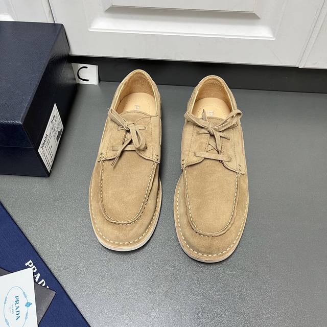 Prada 男士新款系带皮革乐福鞋 这款采用植绒二层牛皮革打造，结合经典设计与手工细节，将精致气息与休闲惬意融为一体。采用系带风格设计，裙饰拼接明线接缝，搭配1