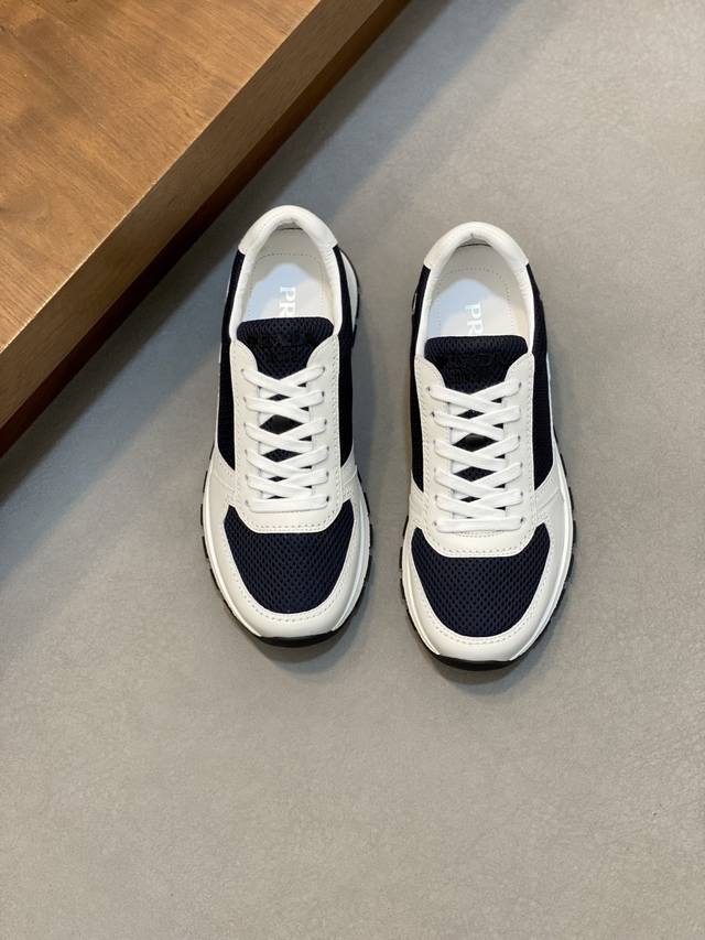 Prada男士新款运动休闲男鞋 这款鞋面采用进口小牛皮和专属客供网布打造，外侧饰以P家经典金属三角珐琅徽标，内里皮里，垫脚牛皮，大底采用防滑运动专属带Logo橡