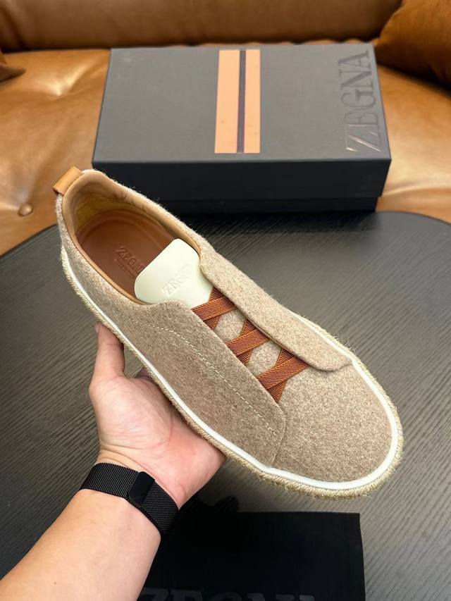 实价 元 杰尼亚 休闲运动鞋 这款 Triple Stitch 低帮运动鞋以柔软的牛皮搭配麂皮制成，为休闲鞋履注入精致格调。标志性三重交叉弹性细节彰显出传统皮鞋