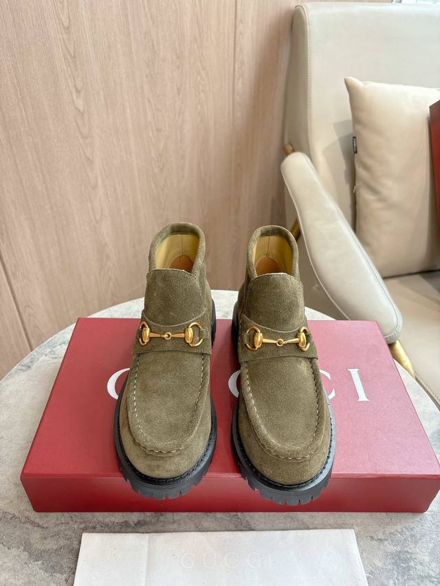 2025-1 绿 35-42 这款马衔扣踝靴采用经典乐福鞋版型，将典藏设计与现代精髓合而为一。这款靴子采用特有的瘦窄版型，以咖啡色绒面材质匠心打造，意在致敬品牌