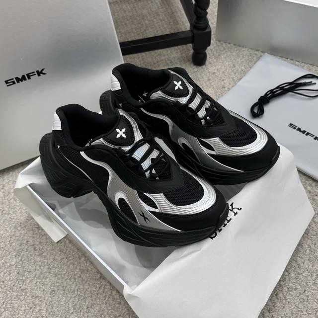 爆款 Smfk 25Ss黑色厚底老爹鞋 采用网面与皮革拼接的材质，兼具透气性与质感。鞋身带有品牌标志性的十字花装饰，辨识度高，黑银配色酷感十足，充满未来科技感。