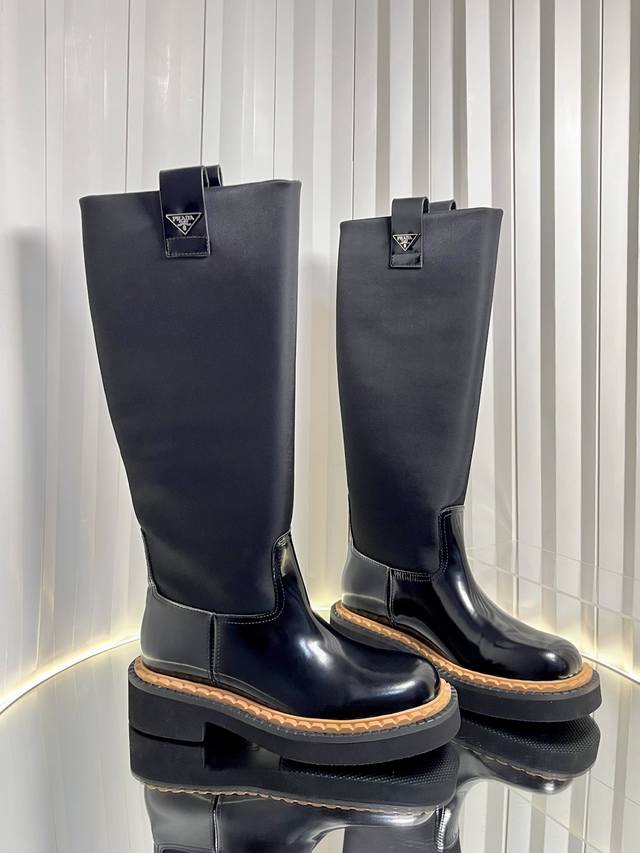 普拉达三角标双沿条锯齿厚底系带及踝靴侧拉链马丁靴机车风短靴 这款皮革短靴融入三角标细节，风格百搭，橡胶鞋底坚实而轻盈，彰显运动风尚与实用性。惯用于精美鞋履的复古