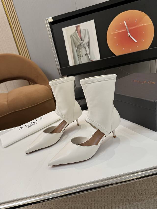 Price: 品 牌：Alaia 阿莱亚25新款箭头弹力短靴中空凉鞋 该款尖头踝靴，采用几何镂空露肤设计，搭配55毫米鞋跟，更加拉长腿部线条比例; 弹力绒面皮山