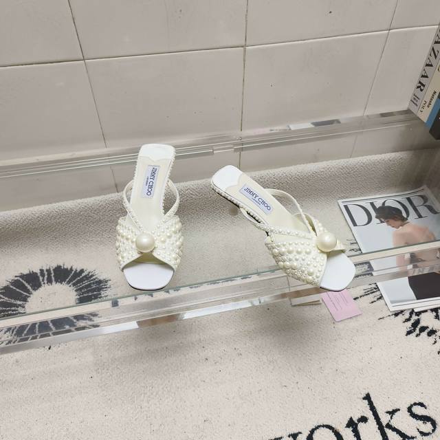 Jimmy Choo Siva Mule系列穆勒鞋，闪耀缎面材质上满铺珍珠，熠熠光芒，引人注目。露趾廓形搭配柔和立体感鞋跟，营造柔美和谐气息，鞋面饰有一颗超大奢
