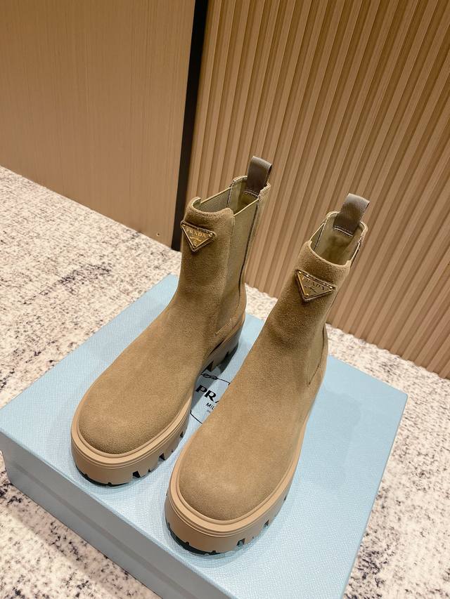 顶级版本： Prada 普拉达 25Fw最新厚底短筒靴 明星同款三角标扣一脚蹬厚底增高机车风松紧带短靴 经典线条与现代元素相结合，定义了此款风格多样的短靴。亮面