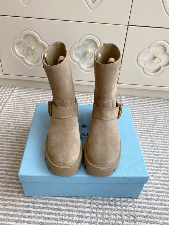 批羊京 牛皮 Prada普拉达新款厚底机车靴 短靴 顶级品质 精致线条与工艺构造定义此款皮革短靴，饰有标志性三角形徽标。独特的金属搭扣为机车风格增添个性，搭配厚