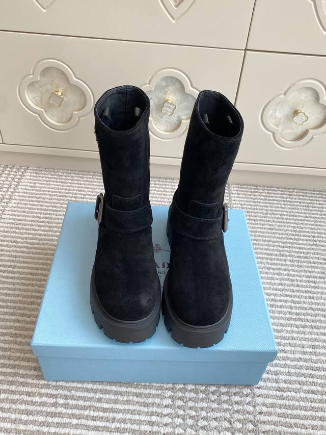 批羊京 牛皮 Prada普拉达新款厚底机车靴 短靴 顶级品质 精致线条与工艺构造定义此款皮革短靴，饰有标志性三角形徽标。独特的金属搭扣为机车风格增添个性，搭配厚