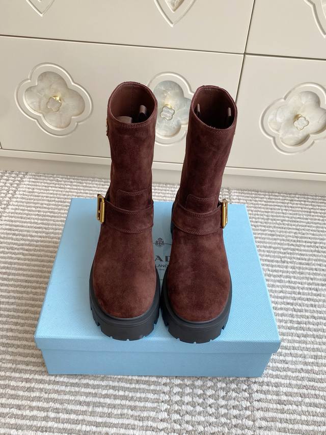 批羊京 牛皮 Prada普拉达新款厚底机车靴 短靴 顶级品质 精致线条与工艺构造定义此款皮革短靴，饰有标志性三角形徽标。独特的金属搭扣为机车风格增添个性，搭配厚