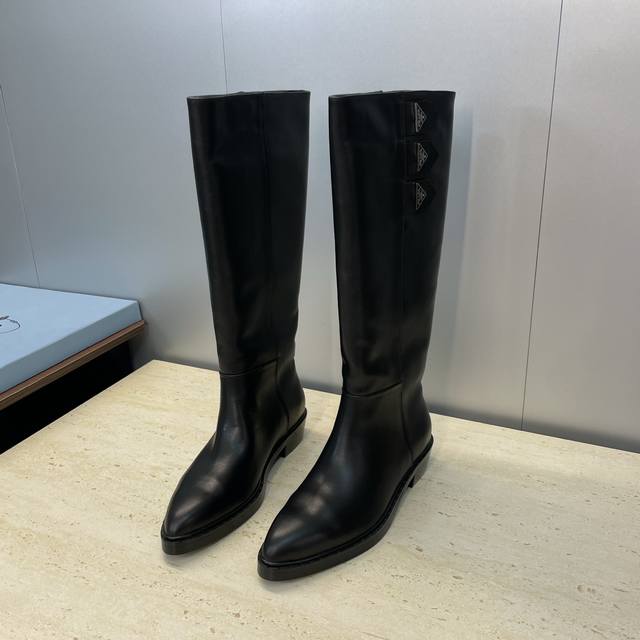 工厂P价P Prada 普拉达 2025秋冬新款游牧风格高筒及膝机车女长靴 明星同款朋克风格低跟尖头标志性字母Logo三角徽章一脚蹬马丁骑士军靴 市面顶级高端版