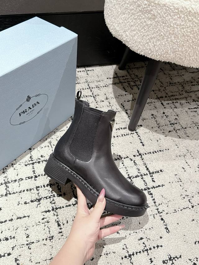 prada普拉达厚底复古马丁靴 橡筋松紧 经典厚底 搭配三角扣 简约大气时尚百搭。 面料进口小牛皮 内里垫脚透染羊皮柔软细腻，脚感舒适 橡胶模具防滑轻便大底 标