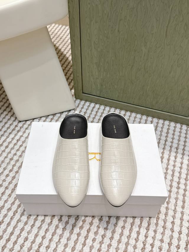 代购级 The Row25Ss牛皮压纹平底穆勒拖鞋 压花皮革，纹理清晰且光泽细腻，既呈现奢华质感，又通过压纹设计增添视觉层次与复古韵味。 延续品牌标志性的极简美