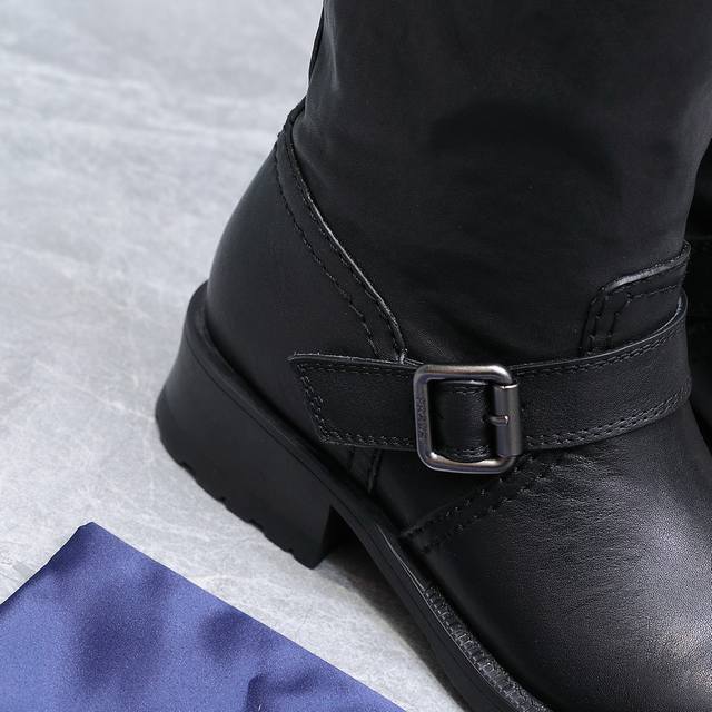 prada 普拉达25Wf秋冬新品皮带扣 复古粗跟长靴 经典的皮带扣设计 如同一把时光钥匙 打开复古与摩登交融的大门。 金属扣的光泽与皮革的质感相互映衬 每一道