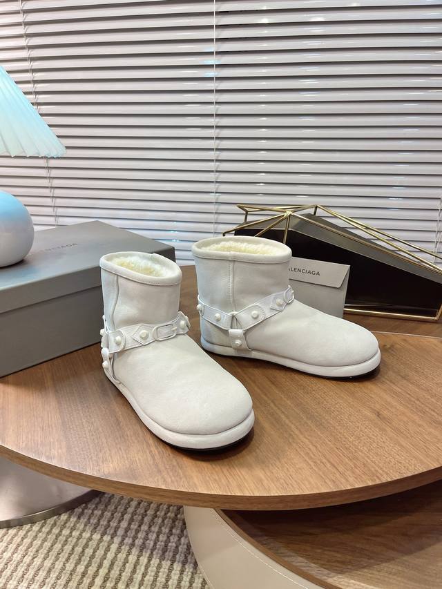 Balenciaga 巴黎世家25Wf新品铆钉 皮带厚底雪地靴 Demna 标志性的拼贴美学 这款雪地靴以双重符号重构冬季风格法则 鞋身错落的金属铆钉并非单纯装