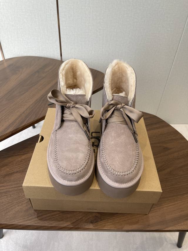 Ugg 25Ss 秋冬保暖带 雪地靴 鞋面采用翻毛皮材质，内里填充羊毛，实现保暖与质感的结合。中筒靴型搭配侧边扣带设计，既提升了造型的时尚感，又可根据穿搭需求调