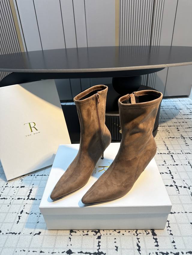 The Row 新款高跟尖头短靴 采用类似麂皮的材质，质感细腻。靴型是修身的短筒设计，侧边有拉链，方便穿脱，能很好地贴合脚踝线条。鞋头为尖头造型，增添了精致感；