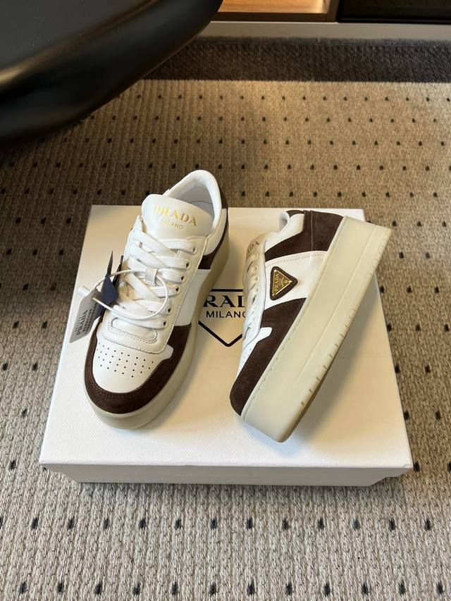 prad*25Ss 厚底拼接休闲鞋 采用皮革+麂皮拼接材质，白色主调搭配深棕 浅棕撞色块，复古氛围浓郁；鞋侧的 prada 三角标标志性元素，提升品牌辨识度。