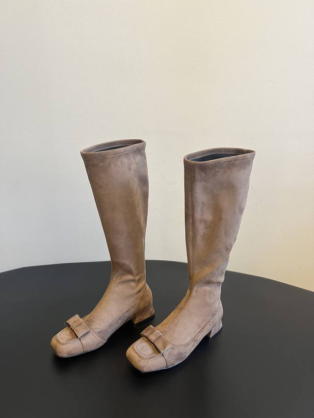 The Row 25Ss复古蝴蝶结长筒靴 延续品牌“极简奢华”的风格，靴型修长流畅，贴合腿部线条，视觉上极具延伸感，轻松打造“大长腿”效果。鞋头处装饰精致蝴蝶结