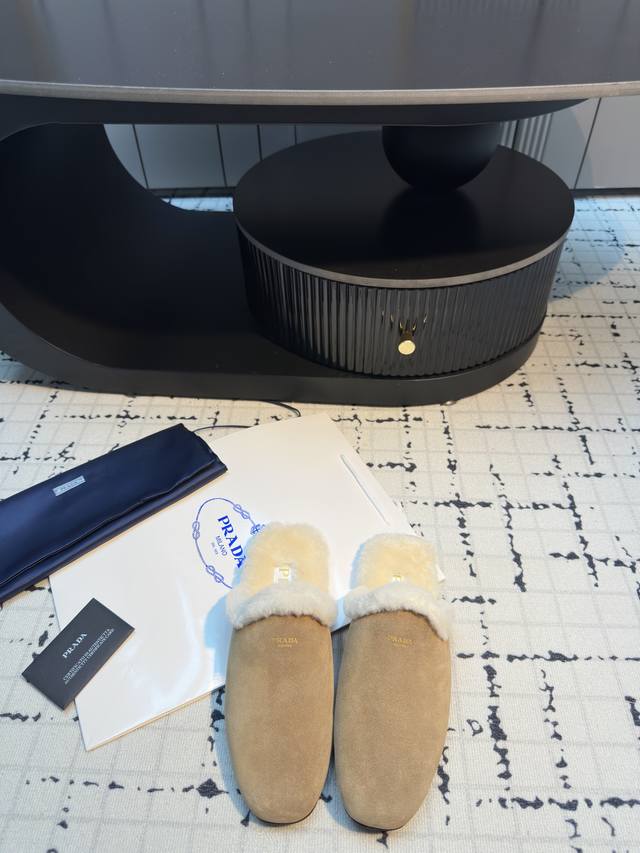 prad* 25Ss普拉达秋冬新款毛绒穆勒鞋 融合了奢华质感与舒适休闲感，鞋面采用高级皮革 麂皮材质，鞋口处的毛绒设计既增添了温暖的视觉效果，又提升了穿着的舒适
