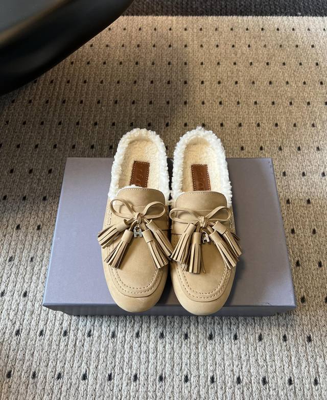Hoga* 反绒皮流苏加绒穆勒鞋 采用反绒皮材质，鞋面质感细腻；鞋内加绒设计，能在冬季提供良好的保暖效果，适合寒冷天气穿着。带有流苏和蝴蝶结装饰，流苏增添了复古