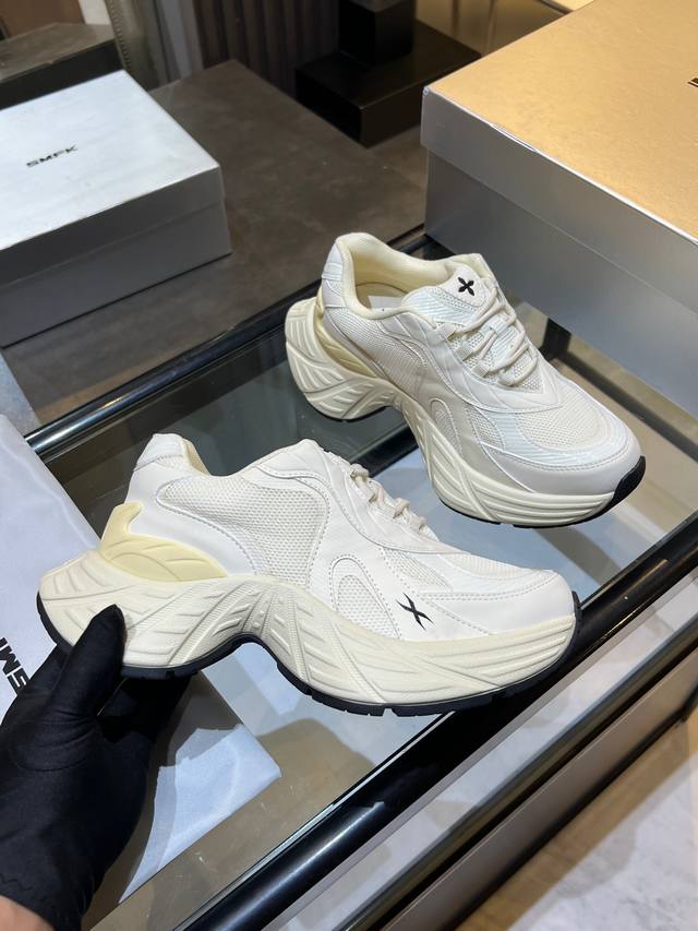 Smfk品牌的厚底老爹鞋，鞋面采用黑色和白色拼接设计，带有独特的十字花纹标识鞋底厚实，具有良好的**效果，适合追求时尚和舒适的人群，在潮流界颇受欢迎，常用于日常