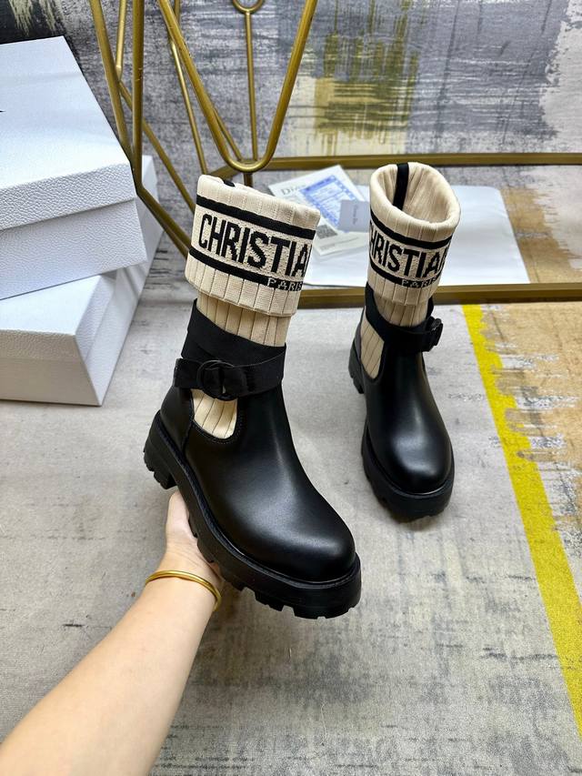 这款D-Major靴子醒目吸睛，彰显个性。黑色牛皮搭配米色调科技针织面料袜筒，饰以标志条纹图案，内里垫脚羊皮。可调节饰带突显脚踝线条厚实而轻盈的凹口鞋底更显精致