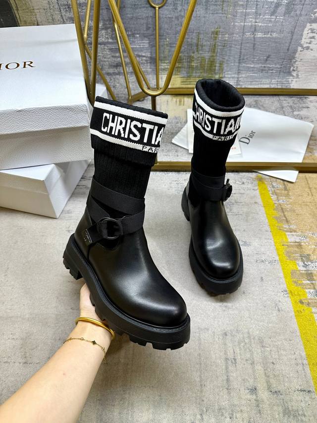 这款D-Major靴子醒目吸睛，彰显个性。黑色牛皮搭配同色调科技针织面料袜筒，饰以标志条纹图案，内里垫脚羊皮。可调节饰带突显脚踝线条厚实而轻盈的凹口鞋底更显精致