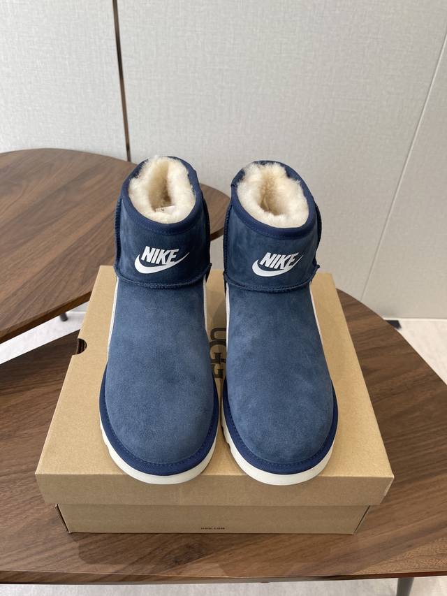 Ugg 联名 Nike 25Ss 秋冬保暖带 雪地靴 鞋面采用翻毛皮材质，内里填充羊毛，实现保暖与质感的结合。中筒靴型搭配侧边扣带设计，既提升了造型的时尚感，又