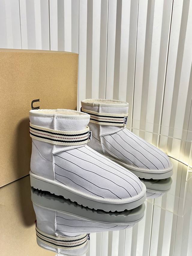 代购级 运动版Ugg 联名 Fila 25Ss 秋冬保暖带 雪地靴 鞋面采用翻毛皮材质，内里填充羊毛，实现保暖与质感的结合。中筒靴型搭配侧边扣带设计，既提升了造