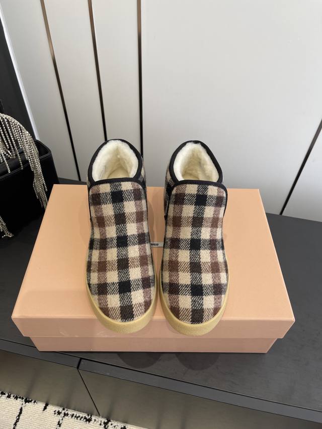 缪缪绒面皮和羊羔毛短靴 柔软轻盈的质感定义了这款绒面皮和羊羔毛短靴的轮廓，结合了高雅与实用性。材质与廓形彰显Miu Miu造型的现代与年轻活力。 刺绣皮革徽标装