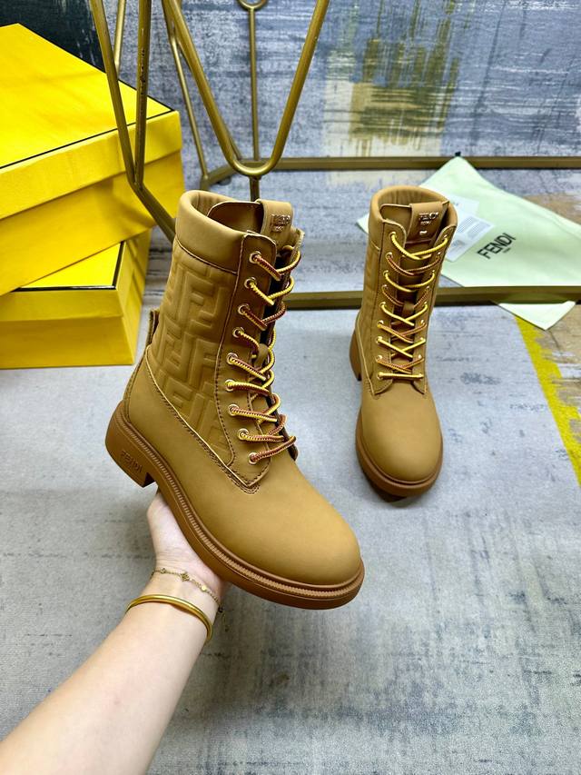Fendi Filo圆头系带军靴。浅棕色防水绒面皮材质，饰有同色系标志性凸纹Ff图案。双色登山鞋带开合，饰金属孔眼。背面饰有金色饰扣。橡胶鞋底，鞋跟侧面饰有Fe